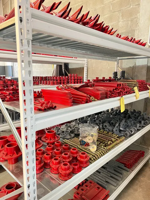 Estantes con piezas rojas y metálicas en las instalaciones de MyG